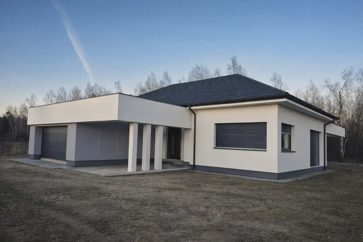 Dom parterowy z białą elewacją, garażem i ciemnym dachem